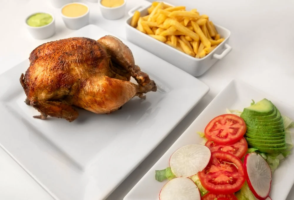 Plate of Peruvian rotisserie chicken with fries and salad